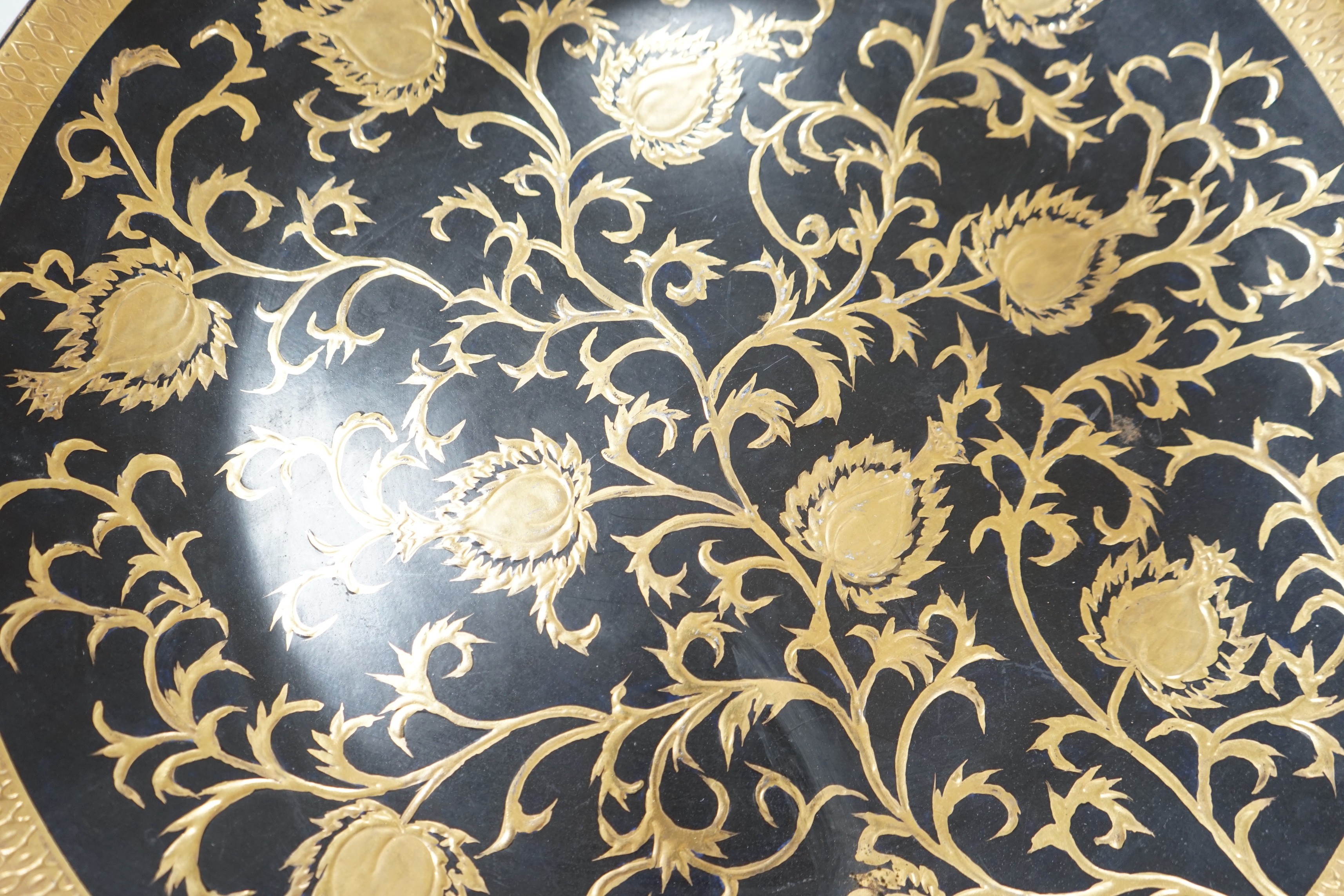A large gilt and black pottery charger, 50cm diameter